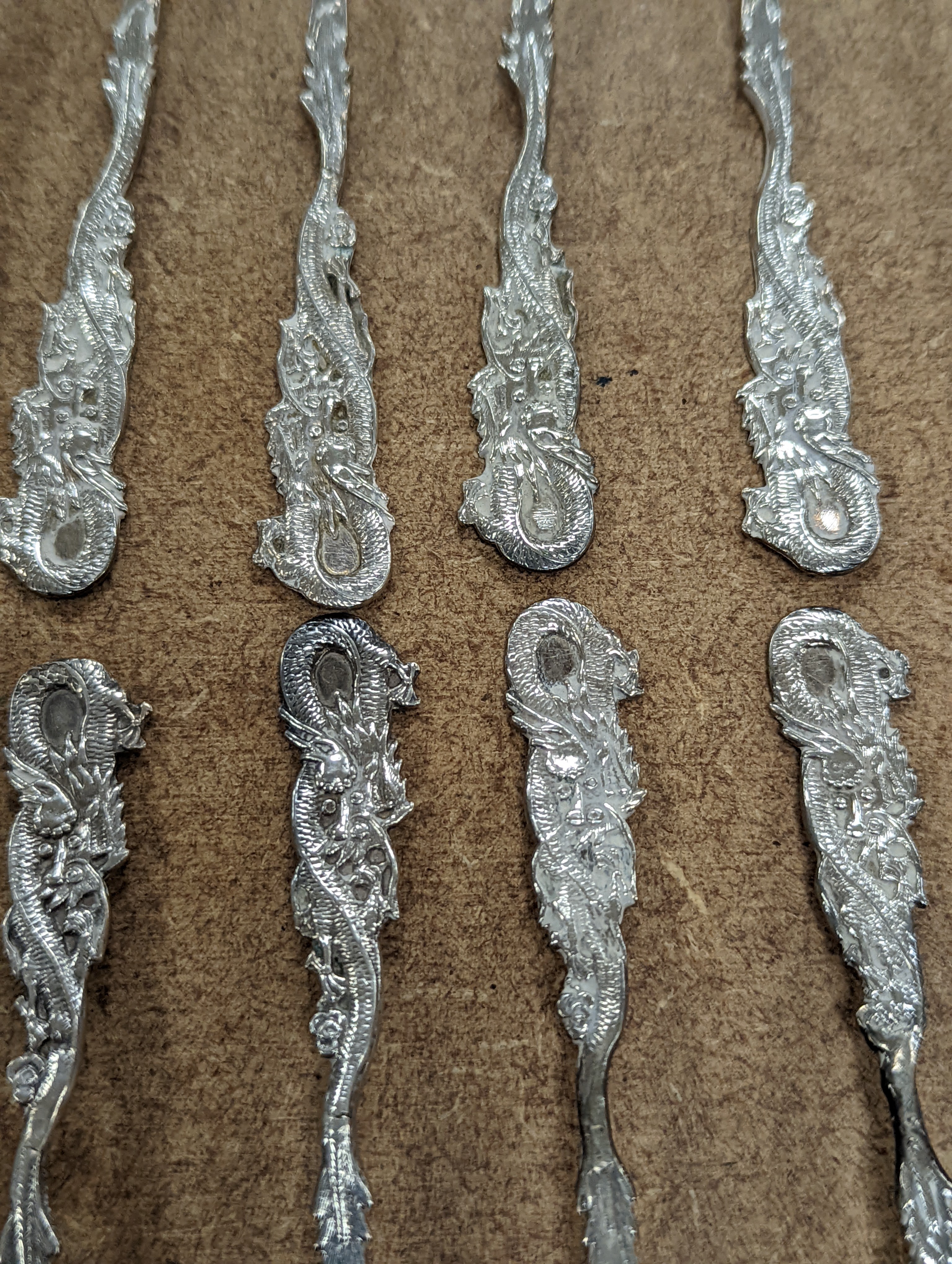 A set of twelve Chinese sterling tea forks, with dragon handles by YCCo and eleven similar teaspoons, 8oz.